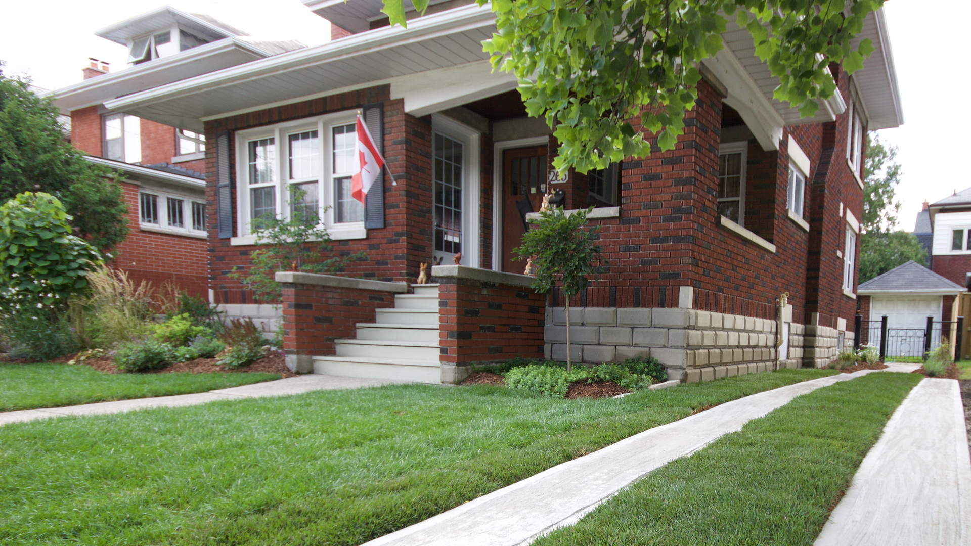 Driveway made with cement-filled tire tracks with fresh sod in between. Traditional landscaping / hardscaping project in London Ontario.