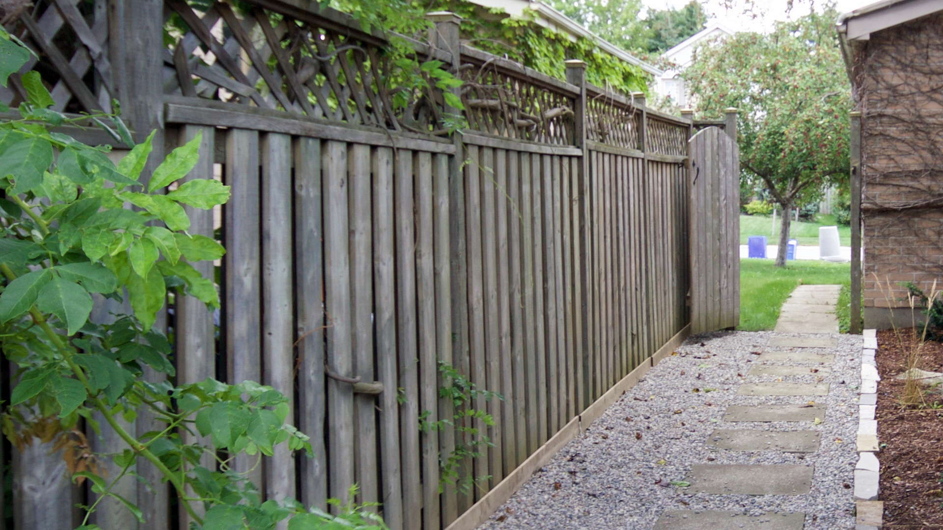 Modern walkway comprised of large square flagstones as stepping stones, with pea stones in between and a natural edge rock border. Modern landscaping / hardscaping project in London Ontario.